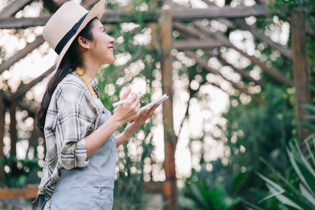 Jonge Aziatische vrouw zorgt voor de tuin