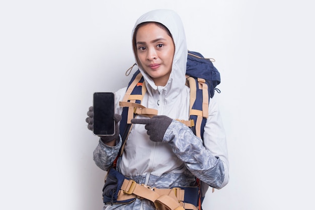 Jonge Aziatische wandelaarvrouw die mobiele telefoon toont die op witte achtergrond wordt geïsoleerd