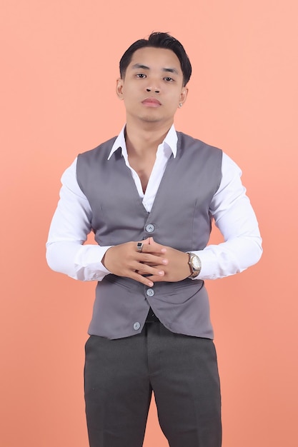 Jonge Aziatische zakenman staart met beide handen zelfverzekerd naar de camera