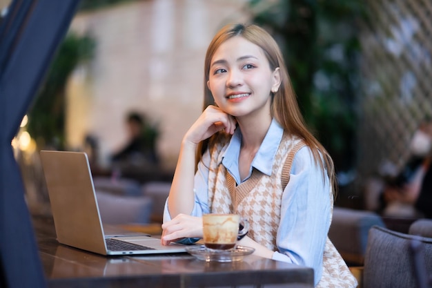 Jonge Aziatische zakenvrouw werken bij coffeeshop