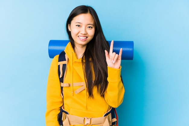 Jonge backpackervrouw die een hoornengebaar tonen als revolutieconcept.