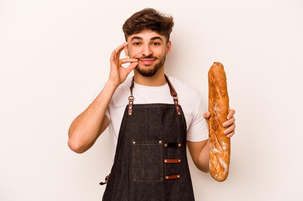 Jonge bakker hispanic man geïsoleerd op een witte achtergrond met vingers op lippen houden een geheim