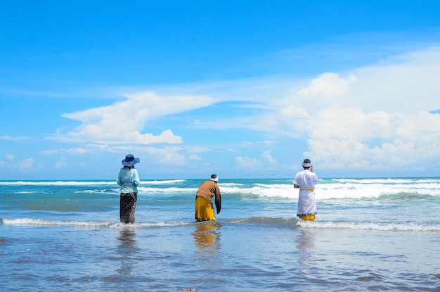 Jonge Balinezen bidden op het strand in Parangkusumo Yogyakarta met traditionele Balinese kleding