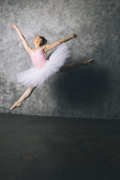 jonge ballerina danser klassiek ballet dansen tegen rustieke muur