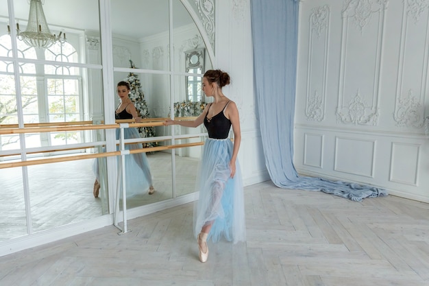 Foto jonge ballerina die balletposities in studio beoefent