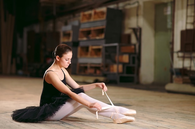 Jonge ballerina in zwarte jurk treinen achter de schermen.