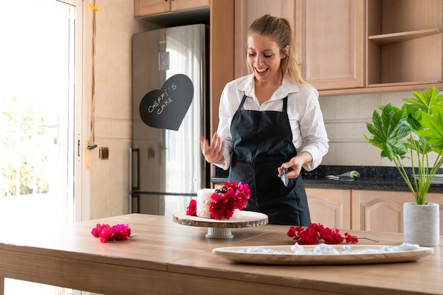 Jonge banketbakker die een traditionele rood fluweelcake in de keuken kookt