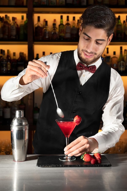 Foto jonge barman die een cocktail serveert in de nachtclub