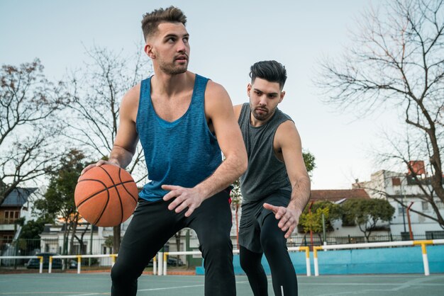 Jonge basketbalspelers die één op één spelen.