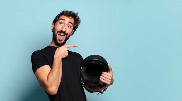 Jonge, bebaarde gekke man met een motorhelm