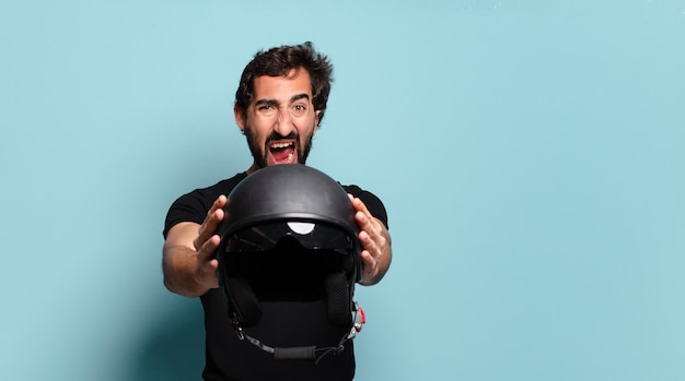 Jonge, bebaarde gekke man met een motorhelm