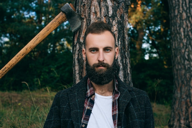 Foto jonge, bebaarde hipster man kijken camera portret in het bos buitenshuis