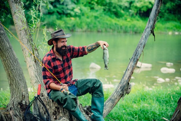 Jonge, bebaarde man aan het vissen in een meer of rivier Vliegvissen