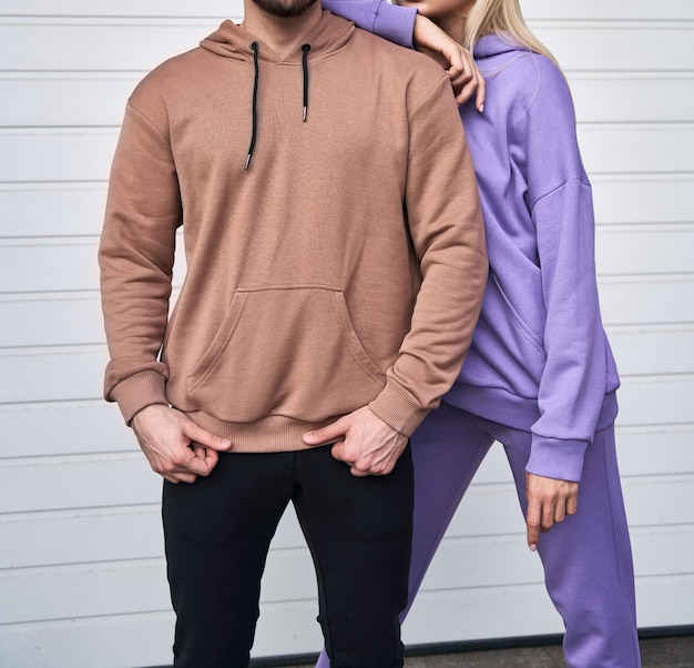 Jonge, bebaarde man en blond meisje staat in effen hoodie voor logo-afdrukken Kledingmodel voor hoodie Herfstkleding voor jongeren