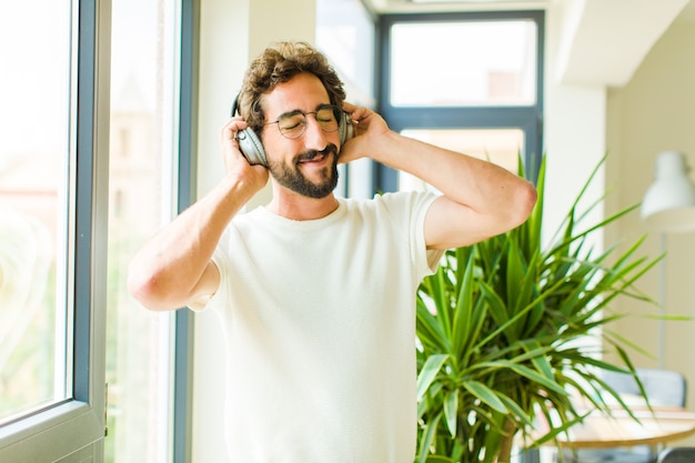 Jonge, bebaarde man, luisteren naar muziek met een koptelefoon