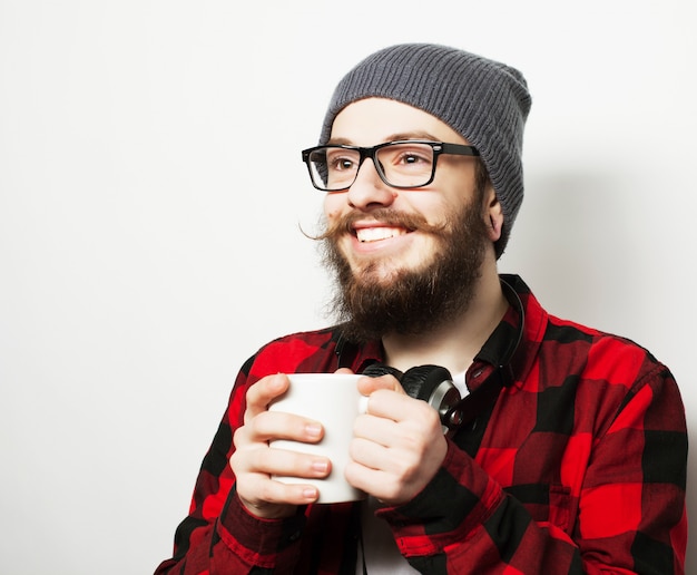 Jonge, bebaarde man met een kopje koffie