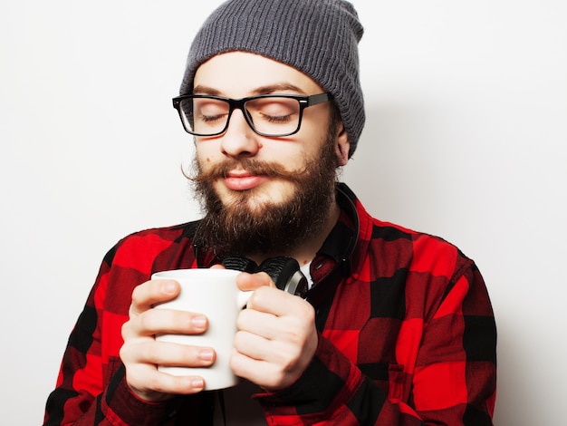 Jonge, bebaarde man met een kopje koffie