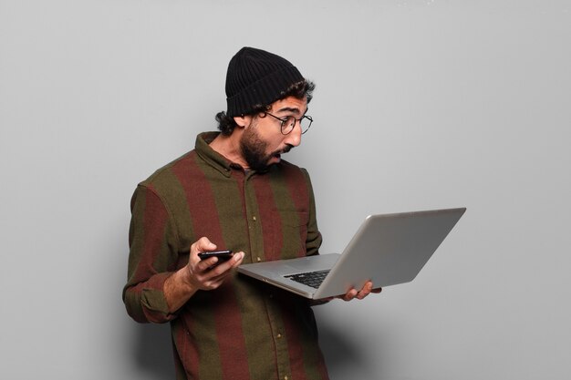 Jonge, bebaarde man met een laptop