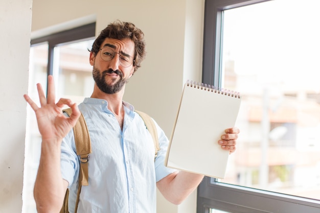 Jonge, bebaarde man met een notitieboek