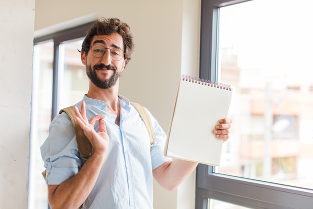 Jonge, bebaarde man met een notitieboek