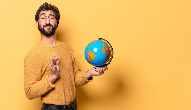 Jonge, bebaarde man met een wereldbolkaart.