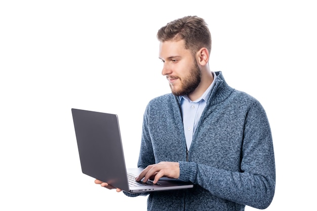 Jonge, bebaarde man met laptop staande