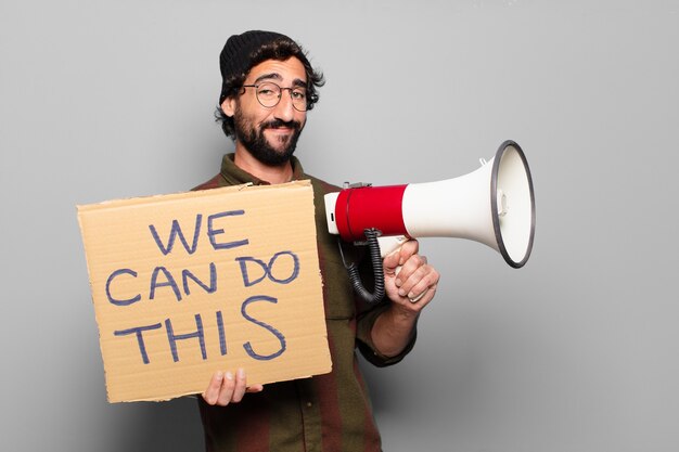 Jonge, bebaarde man protesteert met een megafoon