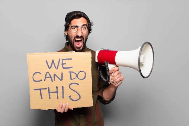 Jonge, bebaarde man protesteren met een megafoon