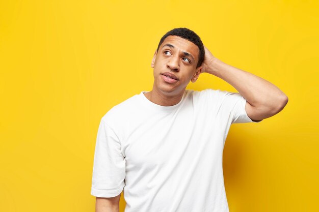 jonge bedachtzame jongen Afro-Amerikaanse verward krabt zijn hoofd en herinnert zich