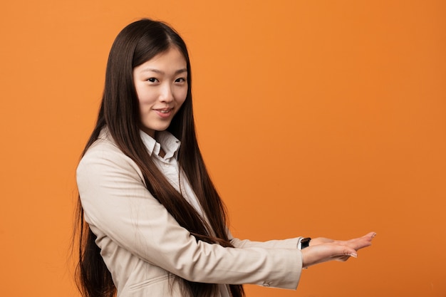 Jonge bedrijfs Chinese vrouw die een exemplaarruimte op een palm houdt.