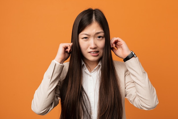 Jonge bedrijfs Chinese vrouw die oren behandelt met zijn handen.