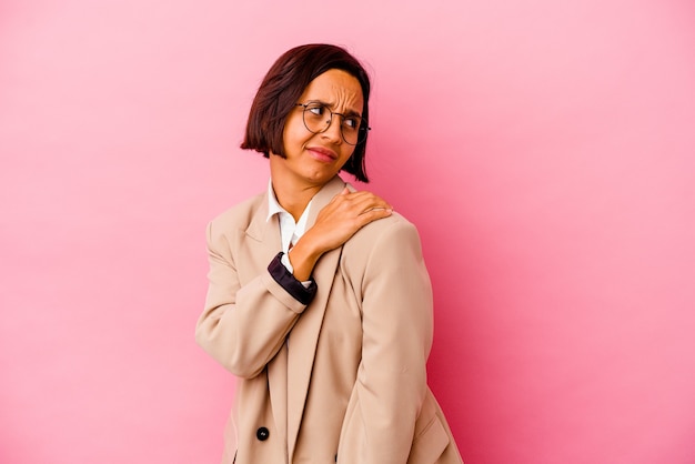 Jonge bedrijfs gemengde rasvrouw die op roze muur wordt geïsoleerd die een schouderpijn heeft