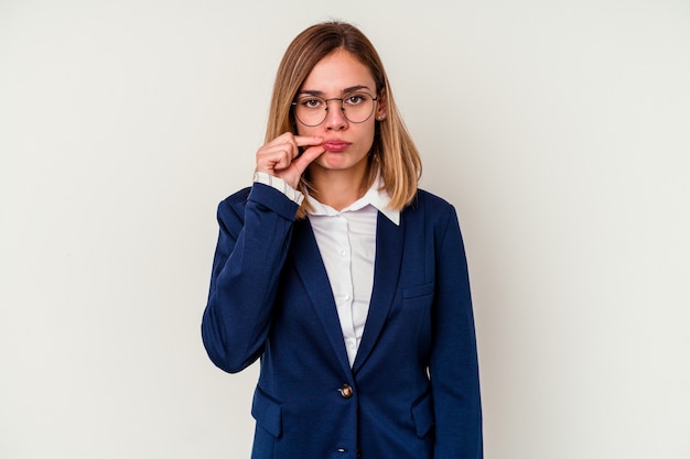 Jonge bedrijfs Kaukasische vrouw die op witte achtergrond met vingers op lippen wordt geïsoleerd die een geheim houden.