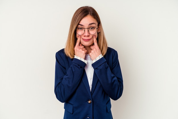 Jonge bedrijfs Kaukasische vrouw die op witte muur wordt geïsoleerd die tussen twee opties twijfelt.