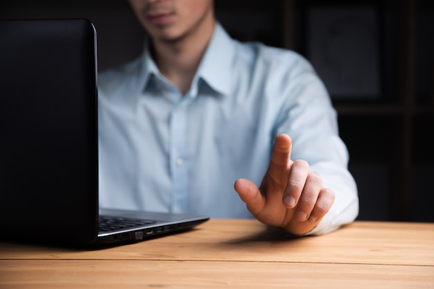 Jonge bedrijfsmens die aan zijn laptop werkt