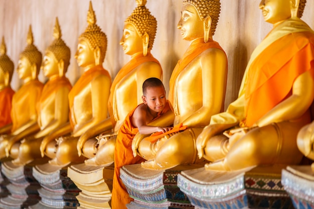 Jonge beginnende monnik die het standbeeld van Boedha schrobt bij oude tempel in Myanmar