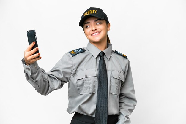 Jonge bewaker vrouw op een geïsoleerde witte achtergrond die een selfie maakt