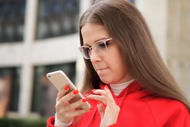 jonge bijziende purblinde student tienermeisje kijken scherm smartphone met behulp van telefoon in bril