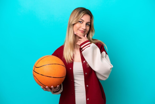Jonge blanke basketbalspeler vrouw geïsoleerd op blauwe achtergrond gelukkig en lachend