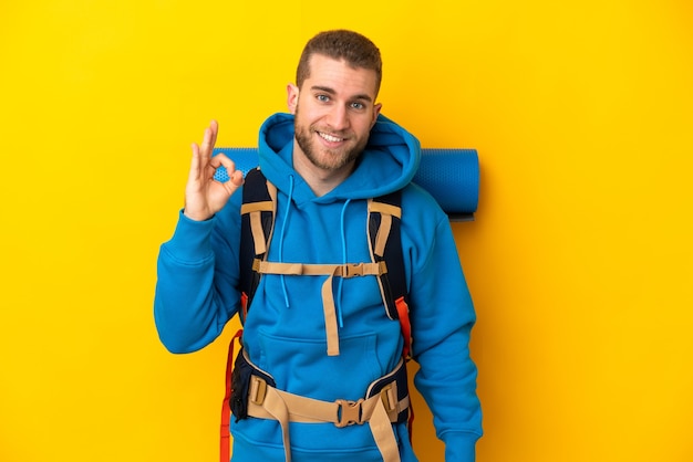 Jonge blanke bergbeklimmer man met een grote rugzak geïsoleerd