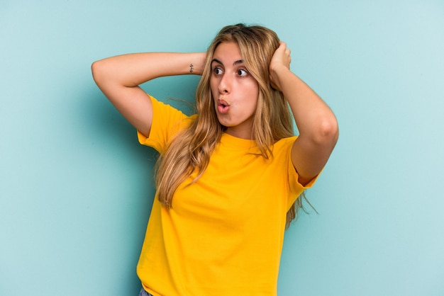 Jonge blanke blonde vrouw geïsoleerd op blauwe achtergrond schreeuwen, erg opgewonden, gepassioneerd, tevreden met iets.