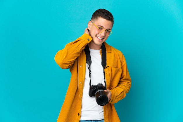 Jonge blanke fotograaf man geïsoleerd op blauw lachen