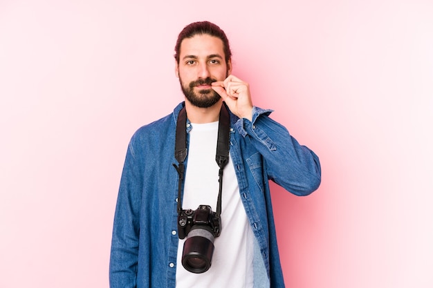 Jonge blanke fotograafmens die met vingers op lippen wordt geïsoleerd die een geheim houden.