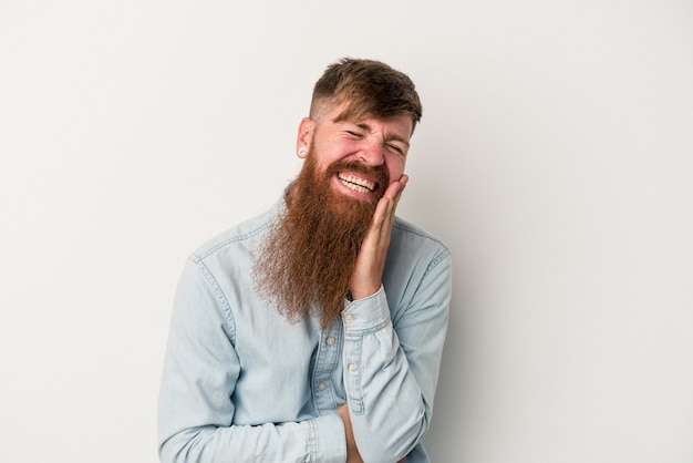 Jonge blanke gember man met lange baard geïsoleerd op een witte achtergrond lacht vrolijk en heeft plezier met het houden van handen op de maag.