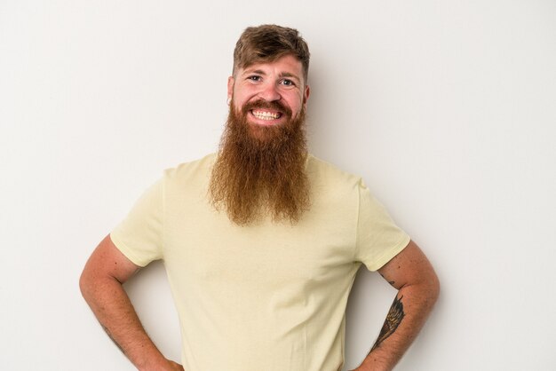 Jonge blanke gember man met lange baard geïsoleerd op een witte achtergrond vertrouwen houden handen op de heupen.