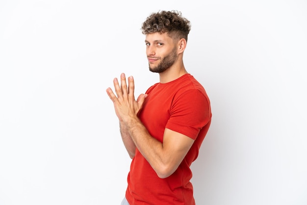 Jonge blanke knappe man geïsoleerd op een witte achtergrond die iets beraamt