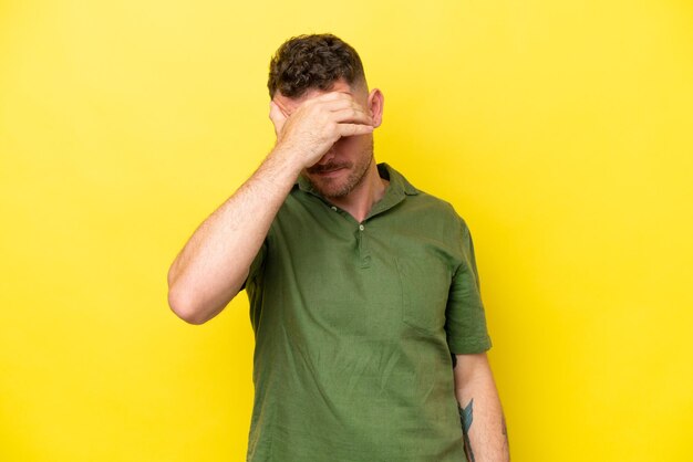 Foto jonge blanke knappe man geïsoleerd op gele achtergrond met hoofdpijn