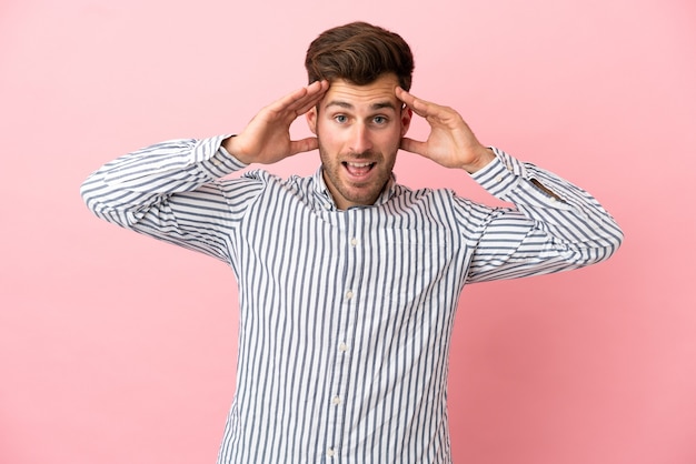 Jonge blanke knappe man geïsoleerd op roze achtergrond met verrassing expression