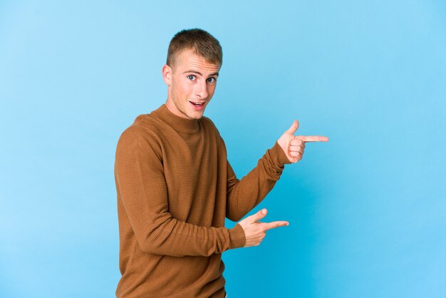 Jonge blanke knappe man opgewonden wijzend met wijsvingers weg.