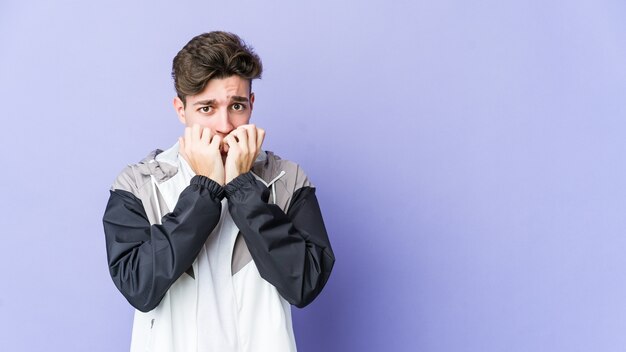 Jonge blanke man bijt nagels, nerveus en erg angstig.